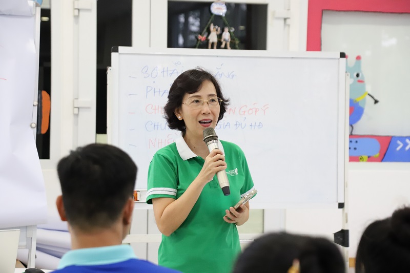 Giáo viên Montessori quan sát trẻ thay vì can thiệp, phản ánh tinh thần tôn trọng nhịp phát triển cá nhân của trẻ nhỏ.